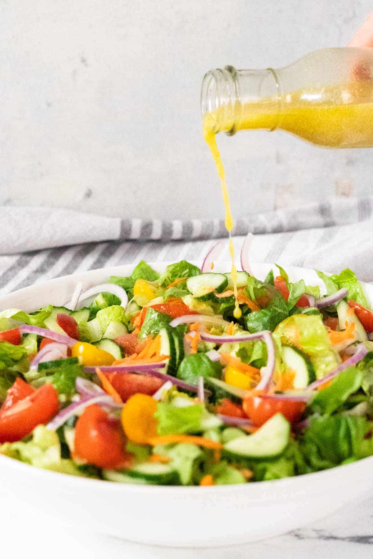 Pouring dressing on a salad.