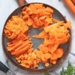 Carrots cut in different shapes on a plate.