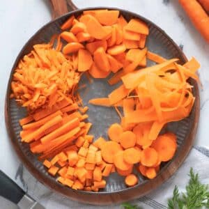 Carrots cut in different shapes on a plate.