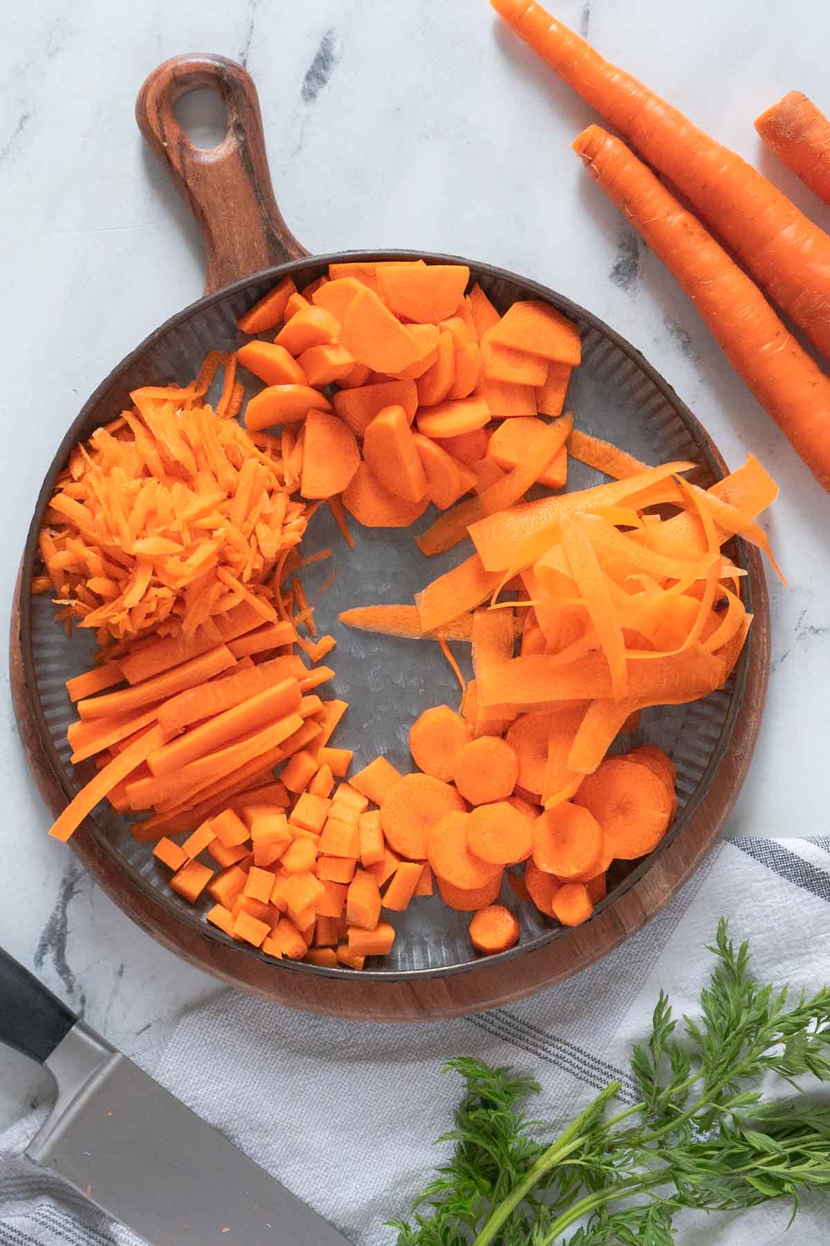 Carrots cut in different shapes on a plate.