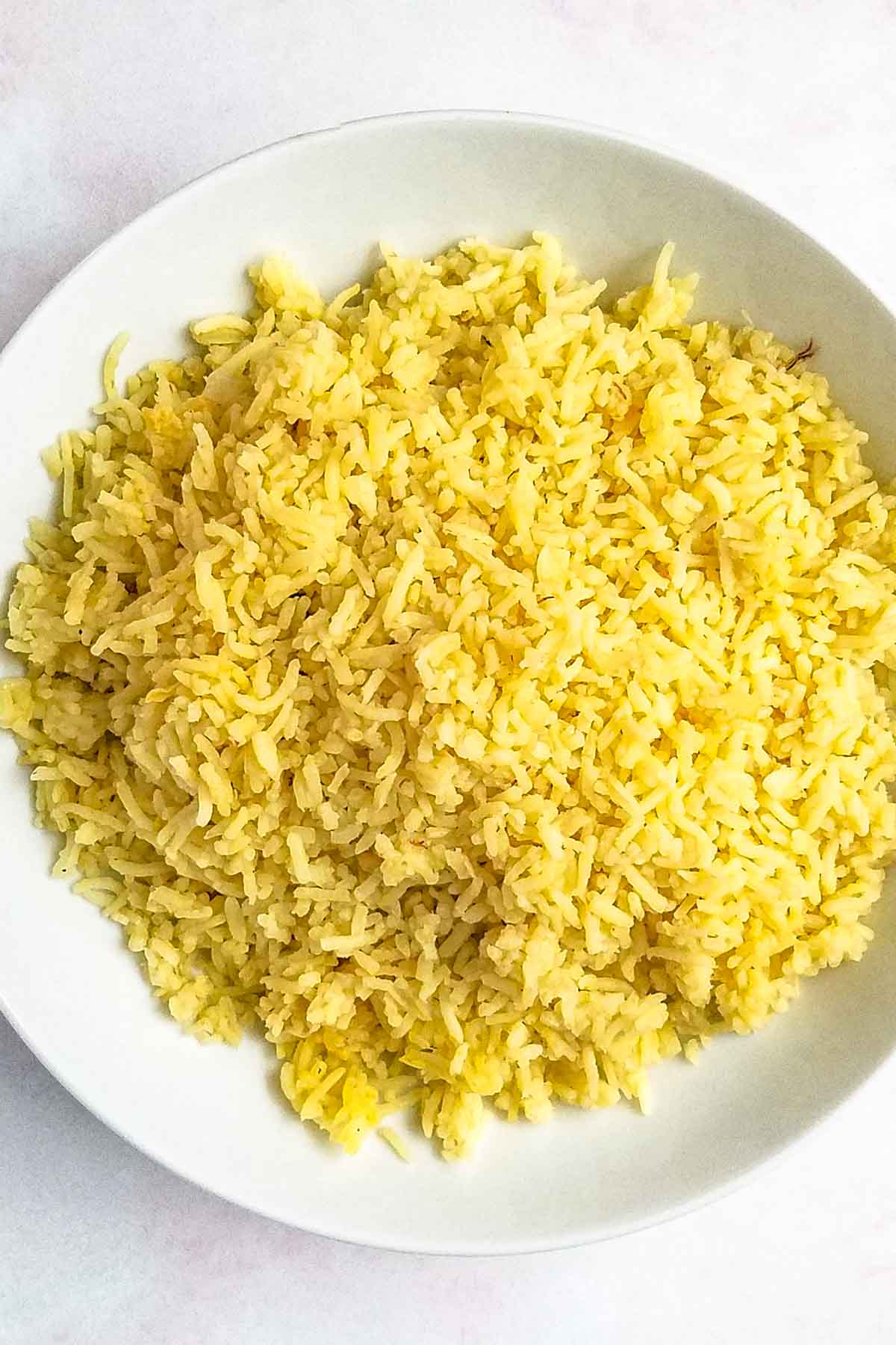 Yellow saffron rice in a serving bowl.