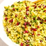 Yellow rice in bowl with fresh herbs.
