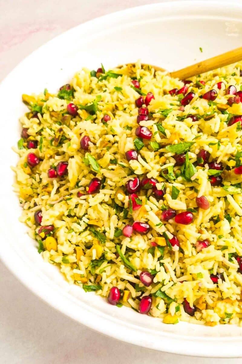 Yellow rice in bowl with fresh herbs.