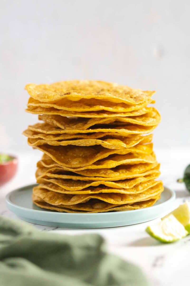 Tostada shells stacked on a plate.
