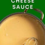 Cheese sauce in a pan with a whisk.
