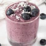 Smoothie in a glass with blueberries.