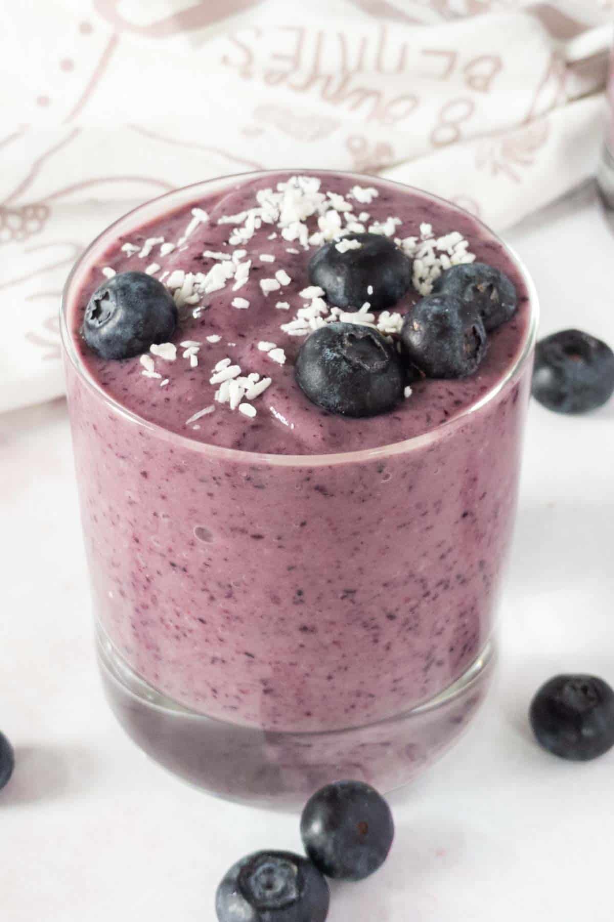 Smoothie in a glass with blueberries.