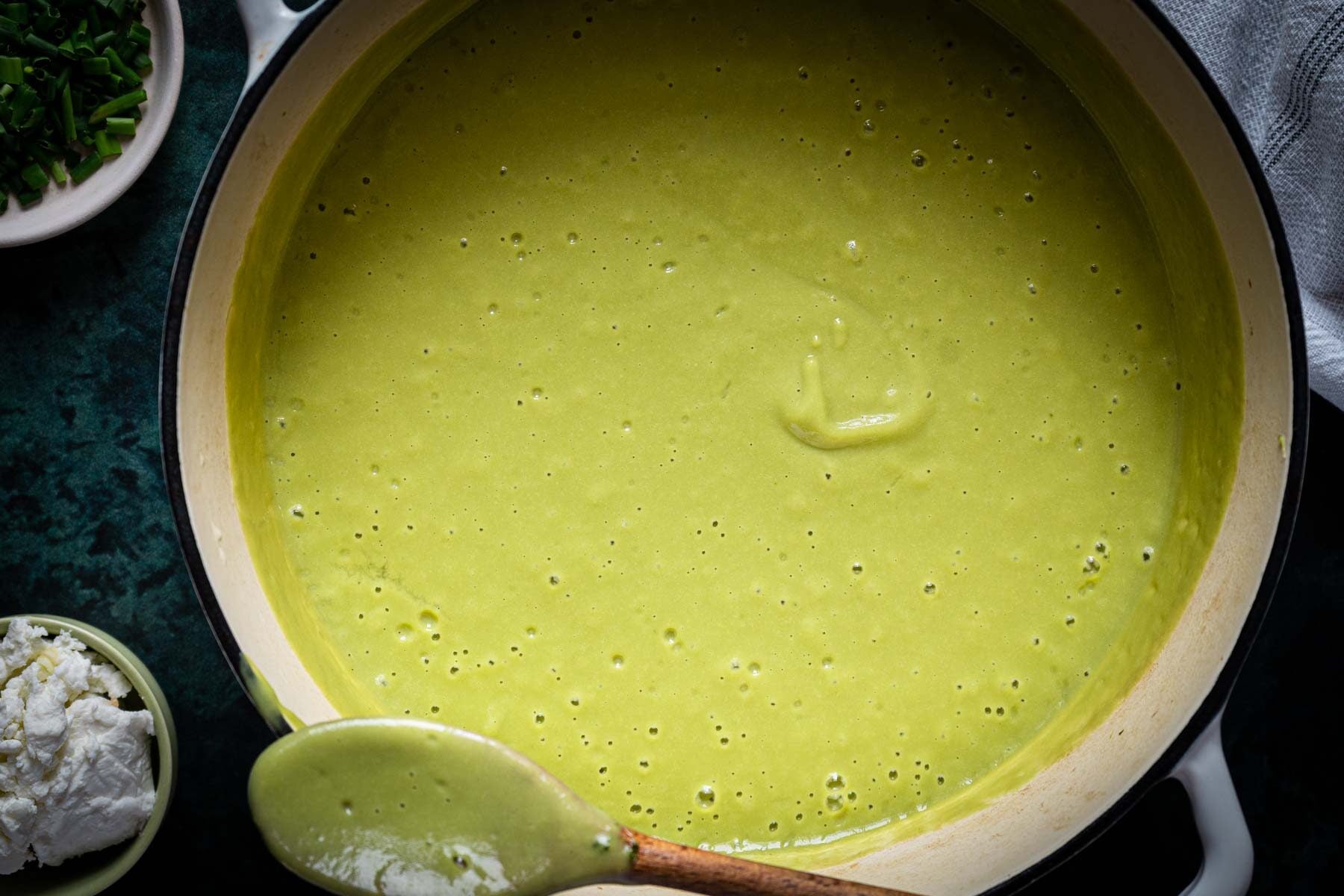 A bowl of vibrant Broccoli Asparagus Soup with a spoon.