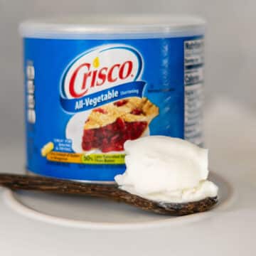 Can of Crisco on a counter with a spoon of vegetable shortening.