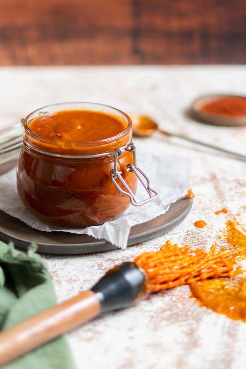 BBQ sauce in a jar with a mop brush.