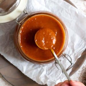 BBQ sauce in a jar with a spoon.