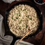 Sausage gravy in a skillet with a wooden spoon.