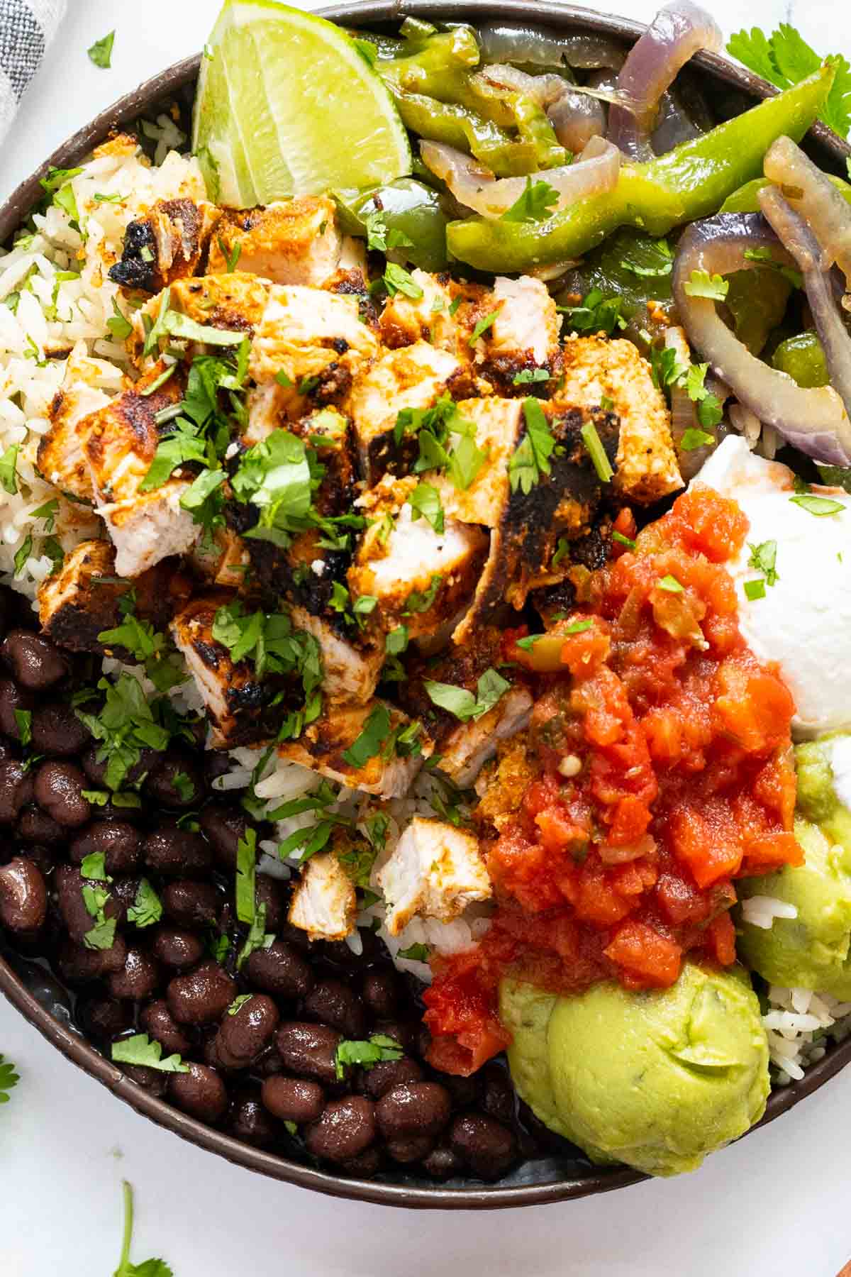 Chicken asada in a rice and black bean bowl.