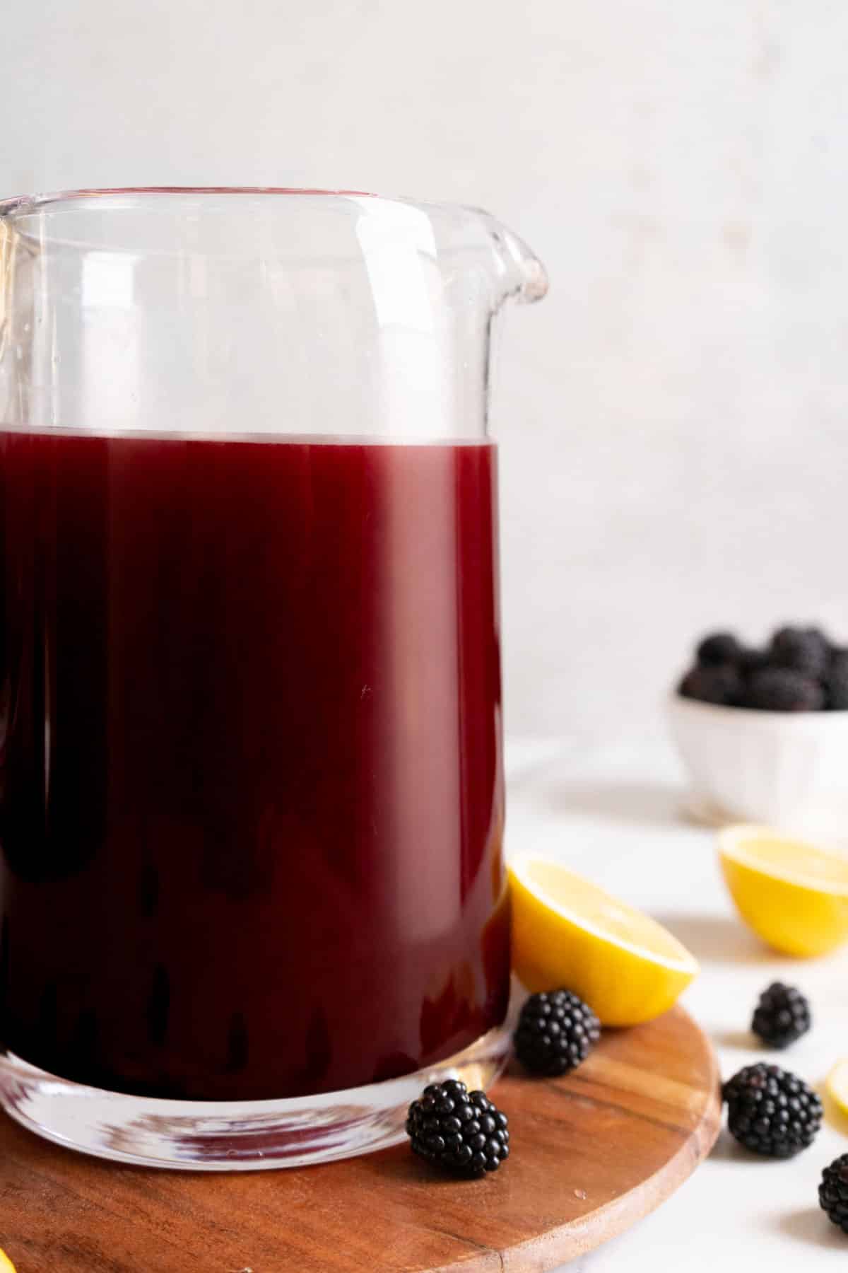 Pouring blackberry syrup into lemonade.