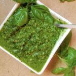 Basil pesto in bowl with spoon.