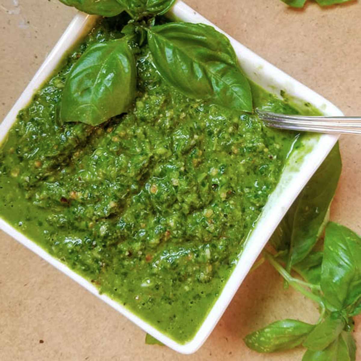 Basil pesto in bowl with spoon.
