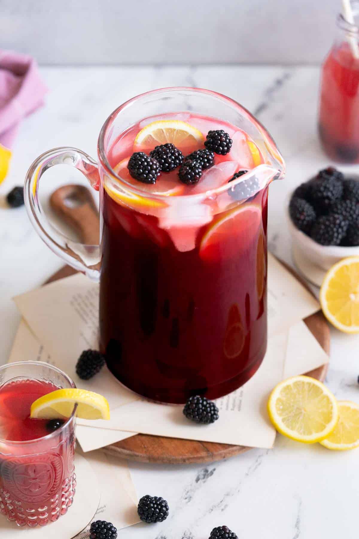 Pitcher of blackberry lemonade with fresh fruit.