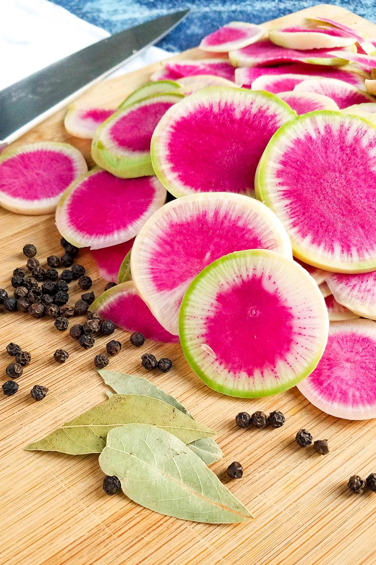 Sliced pink radishes on a cutting board.