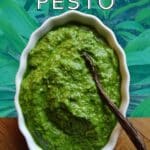 Pesto in a bowl with a wooden spoon.