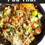 Pad thai in a pan with a wooden spoon.
