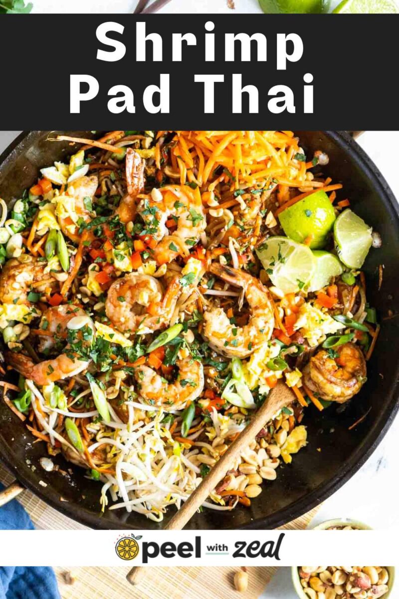 Pad thai in a pan with a wooden spoon.