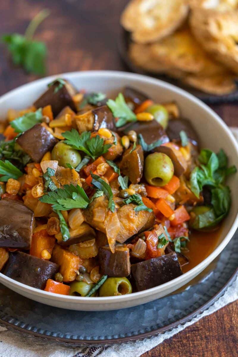roasted eggplant caponata in a bowl with fresh herbs,