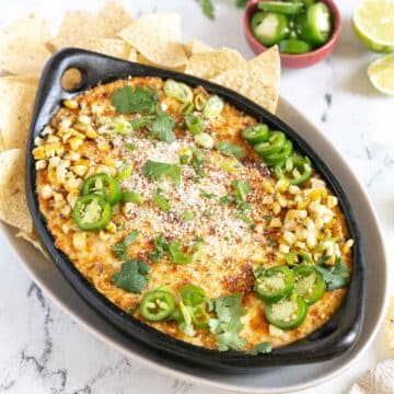 Baked cheese dip in a pan with corn chips.