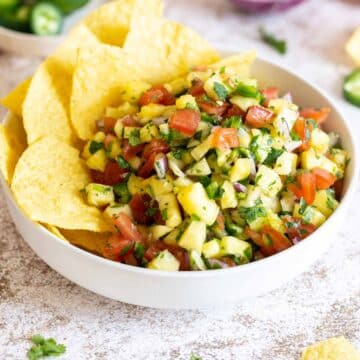 Pineapple pico de gallo in a bowl with tortilla chips.