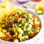 Pineapple pico de gallo in a bowl with tortilla chips.