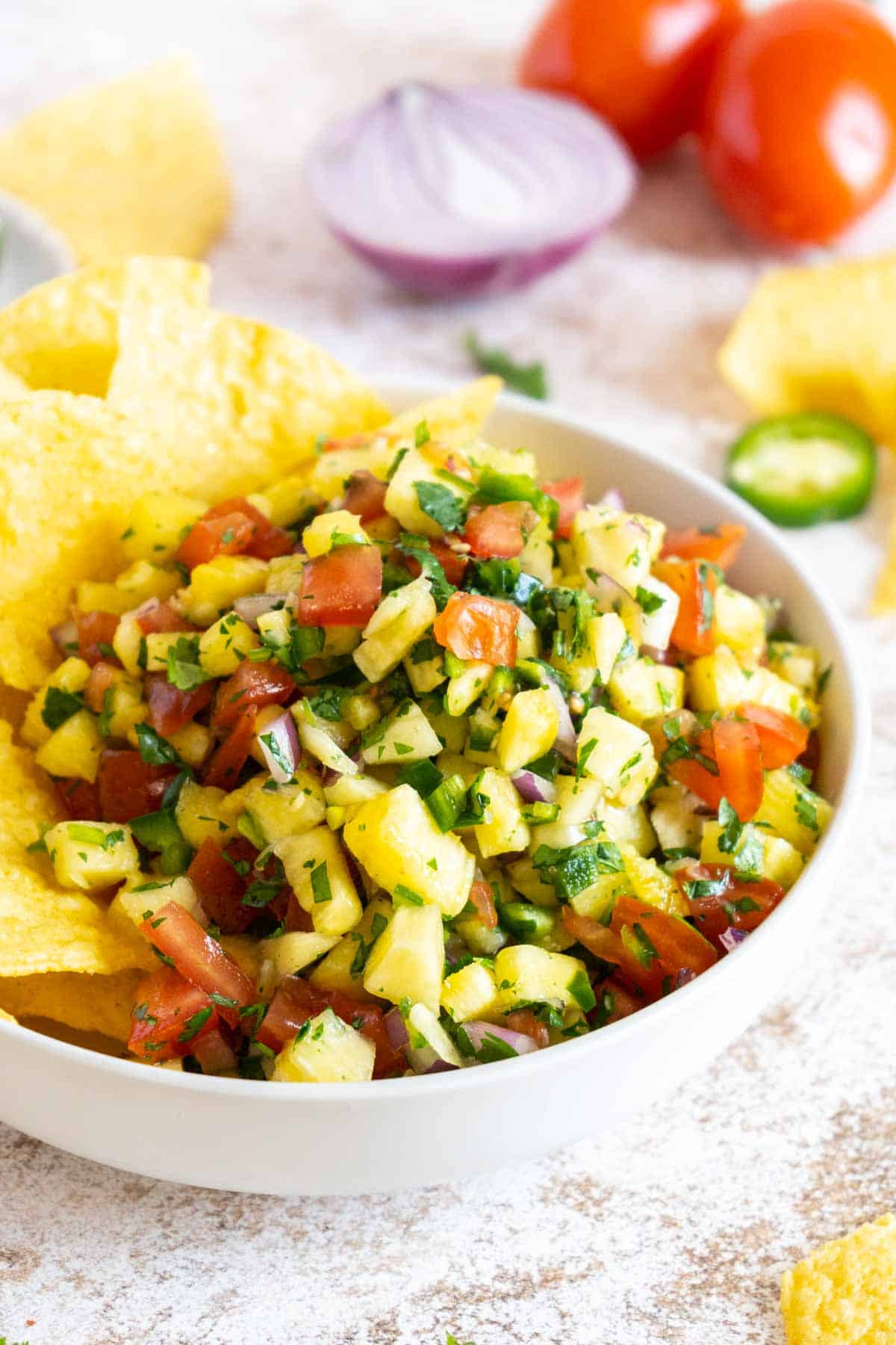 Pineapple pico de gallo in a bowl with tortilla chips.