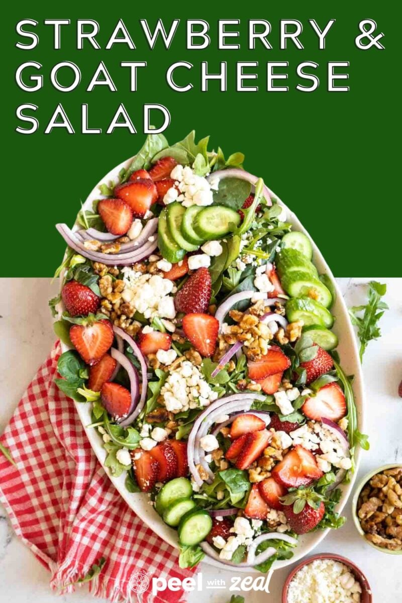 A strawberry salad with goat cheese on a platter with a gingham napkin.