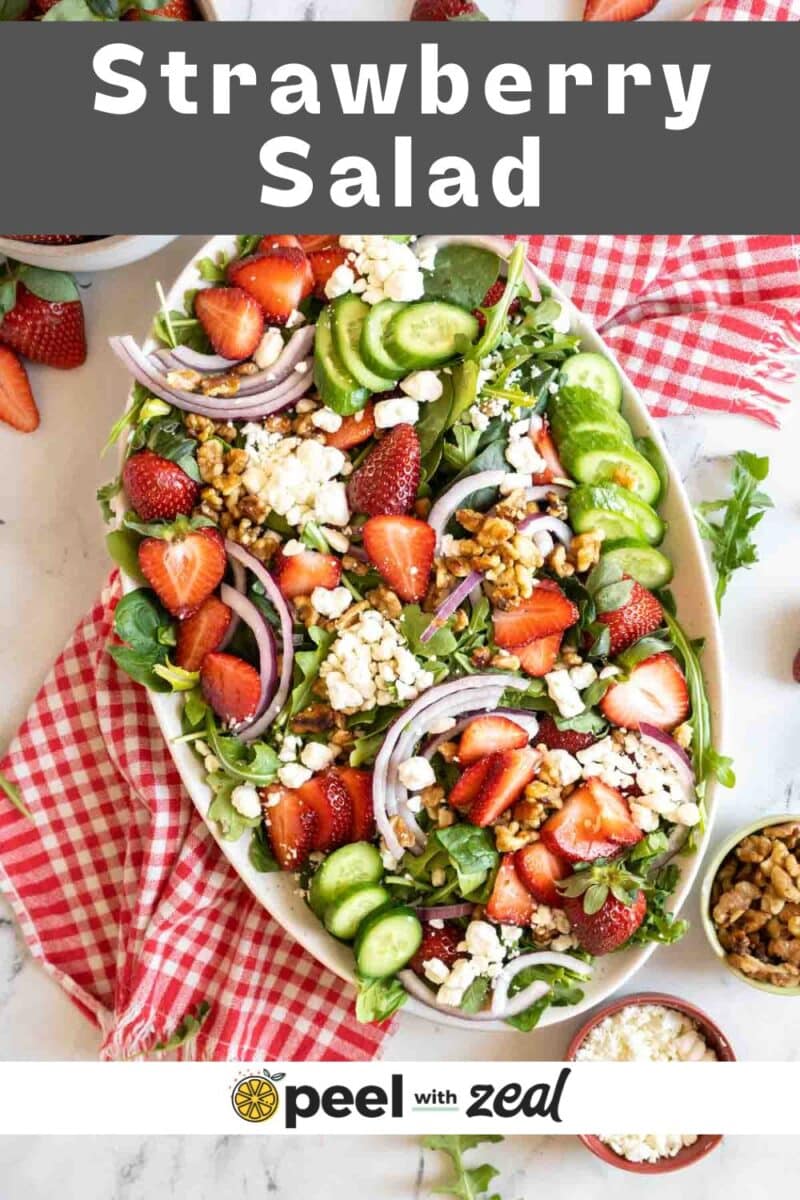 Spinach and arugula salad with strawberries on a platter.