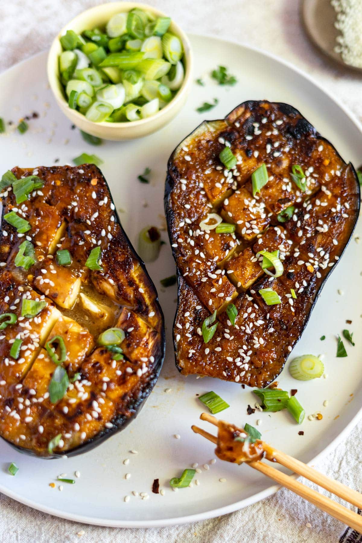 Miso baked eggplant with scallions on a plate.