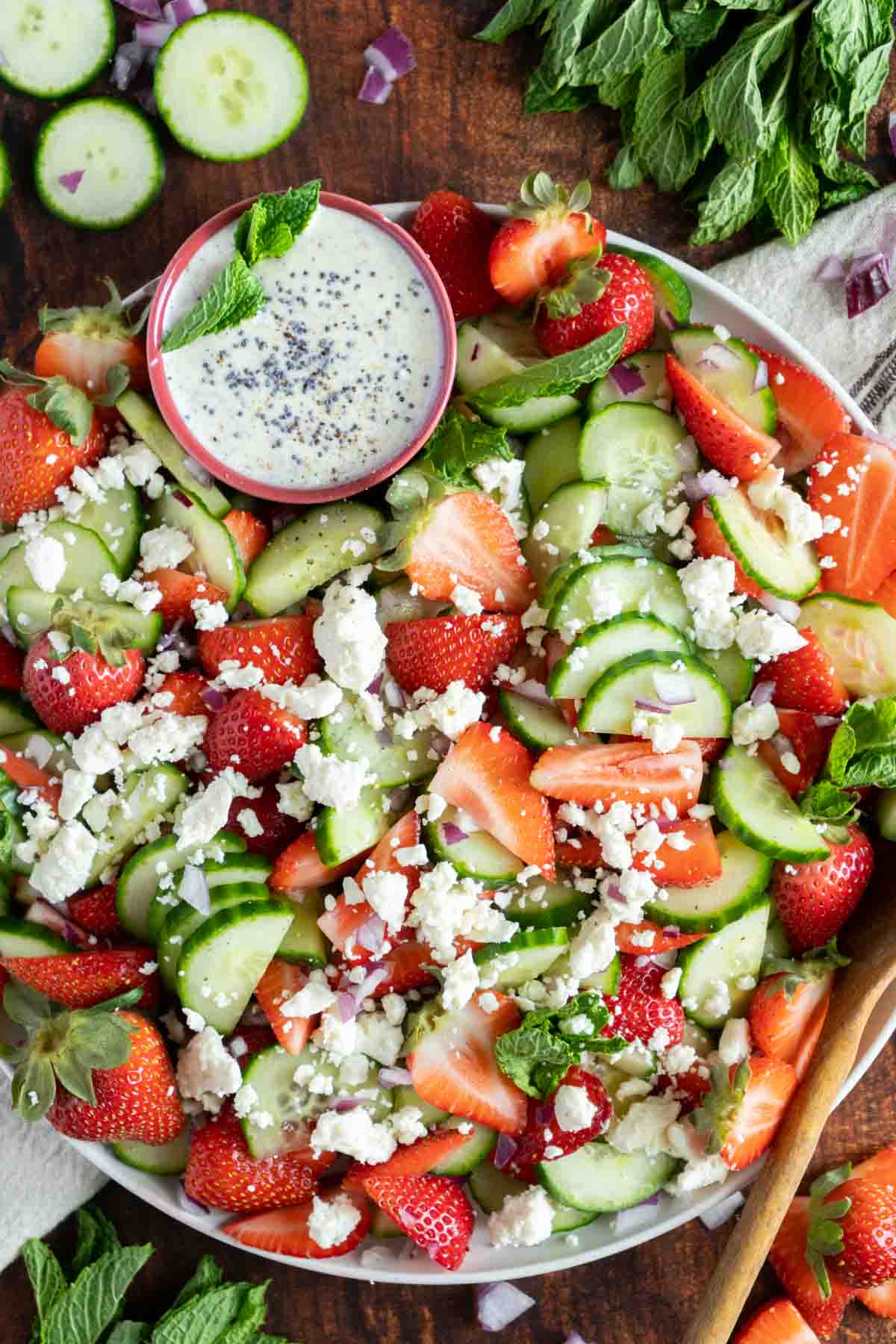 Salad on a plate with mint, feta, berries, and cucumber,