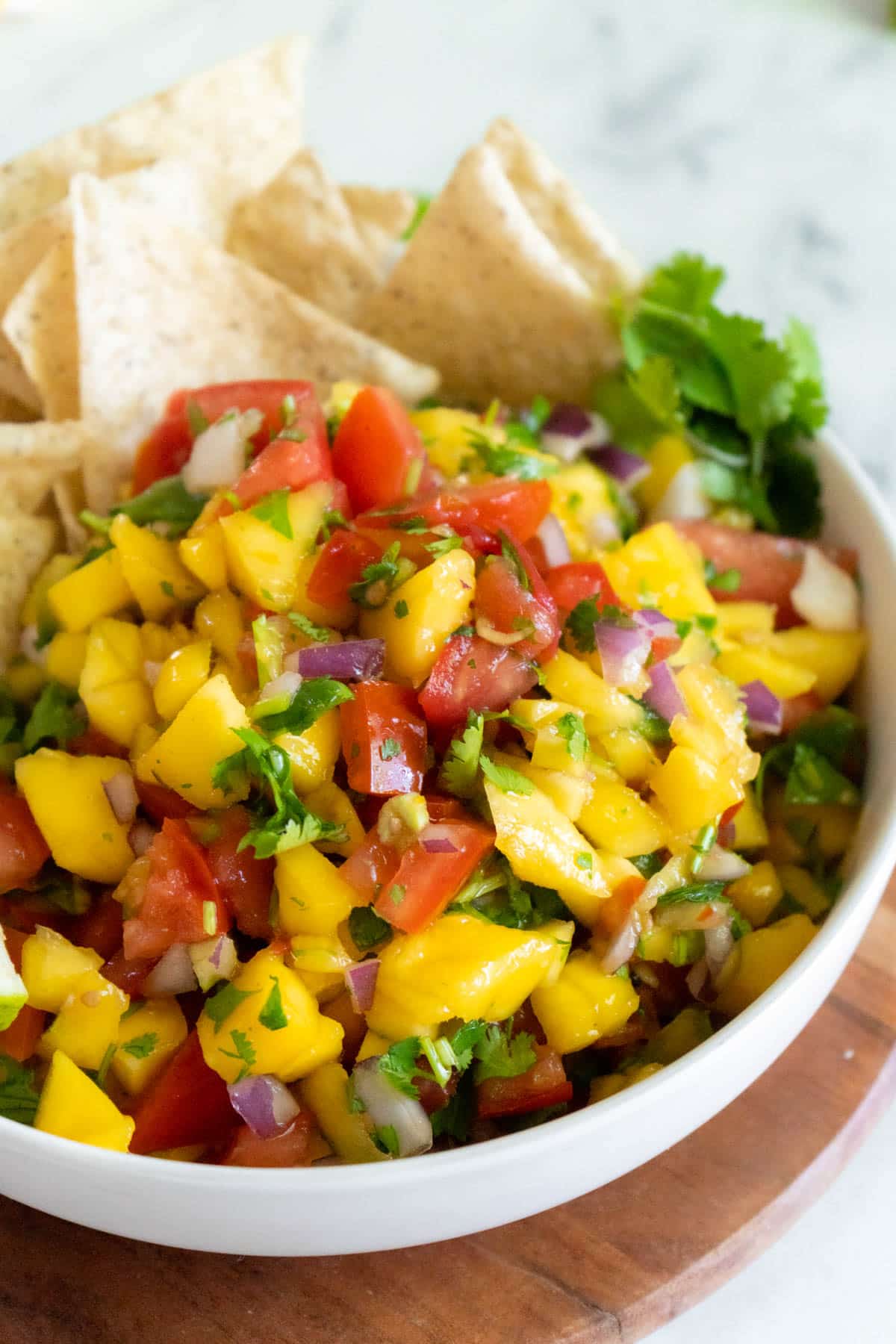 Mango pico dip in a bowl with tortilla chips.