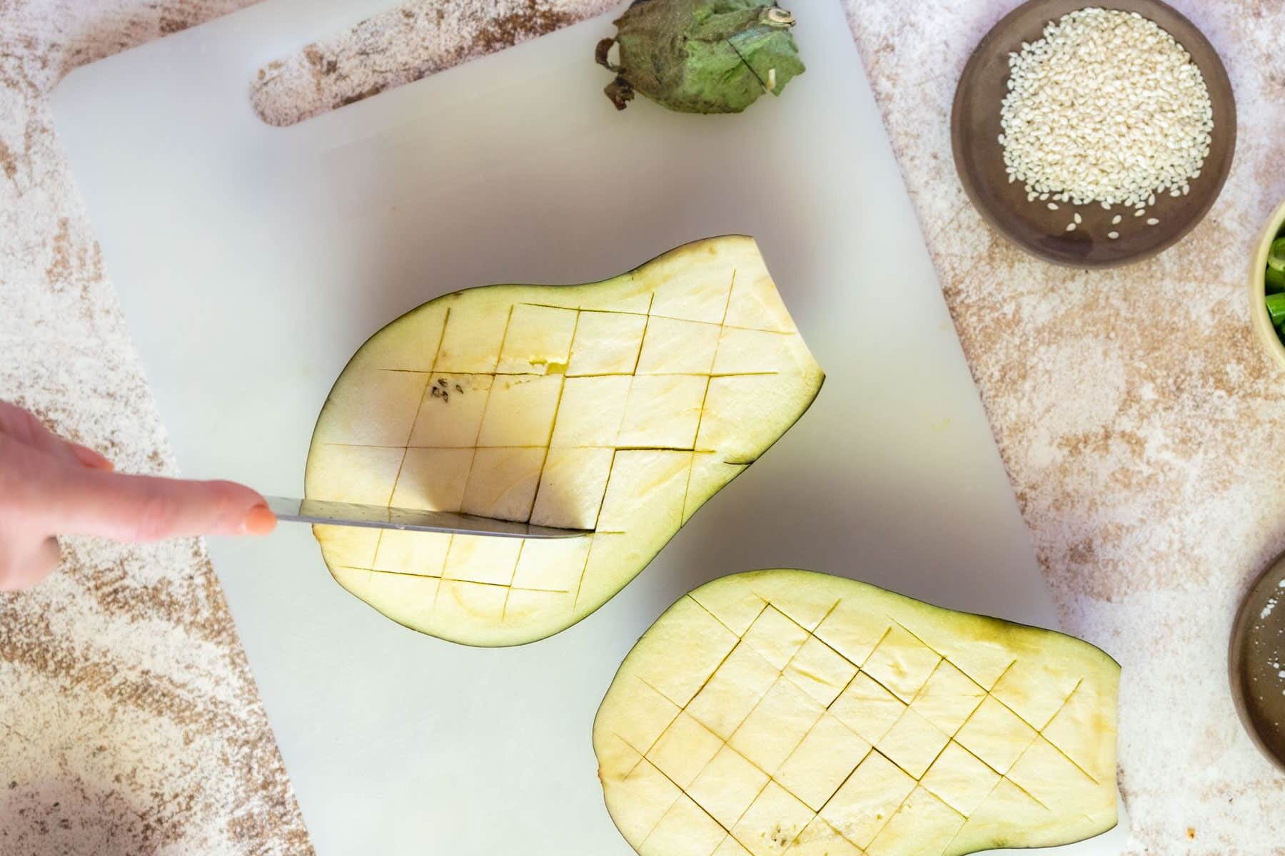 cutting the eggplant in a cross hatch pattern.