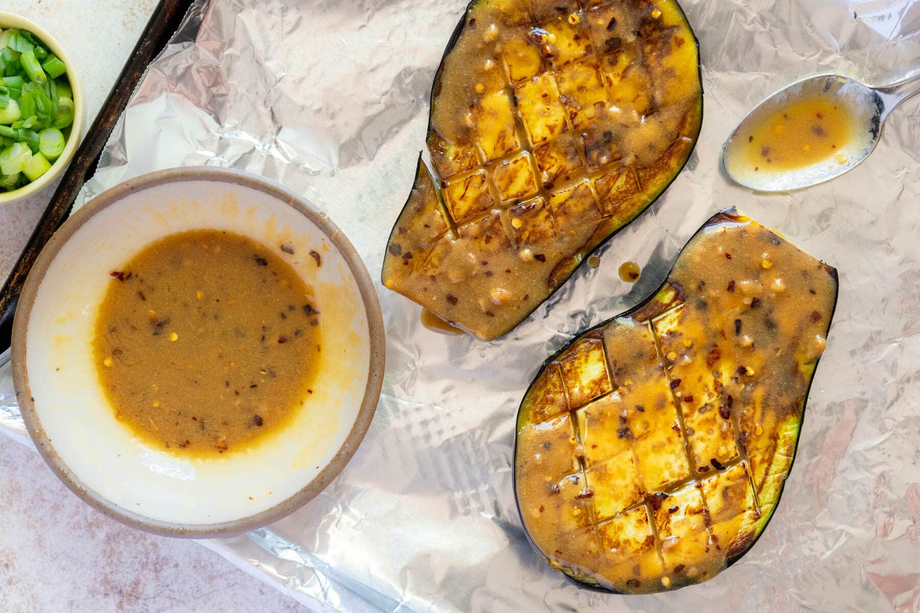 Glaze in a bowl and eggplants with miso glaze on top. 