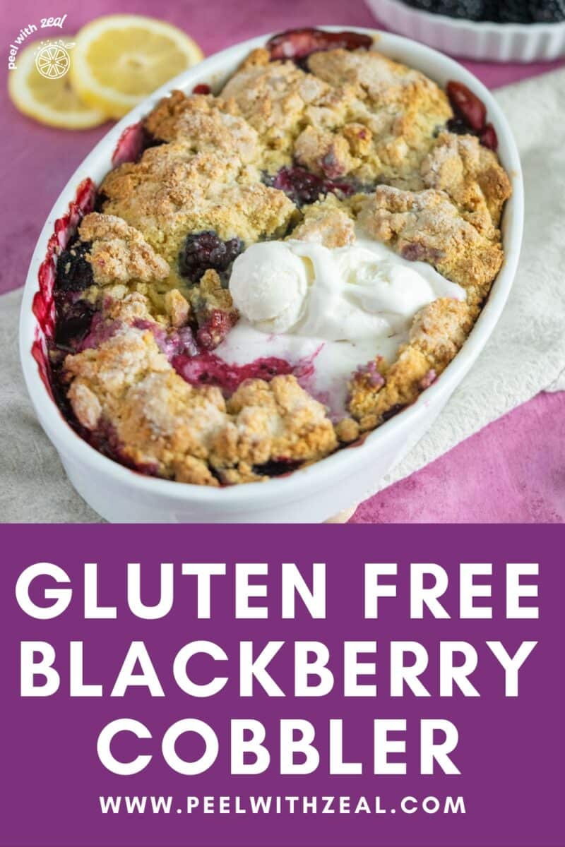 Blackberry cobbler in a baking dish with 2 scoops of ice cream.