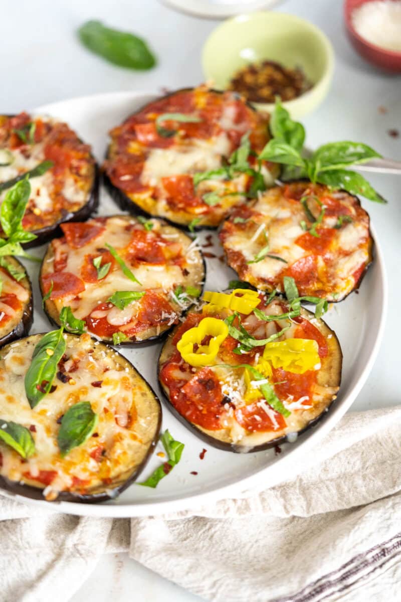 Eggplant pizzas on a plate with different toppings.