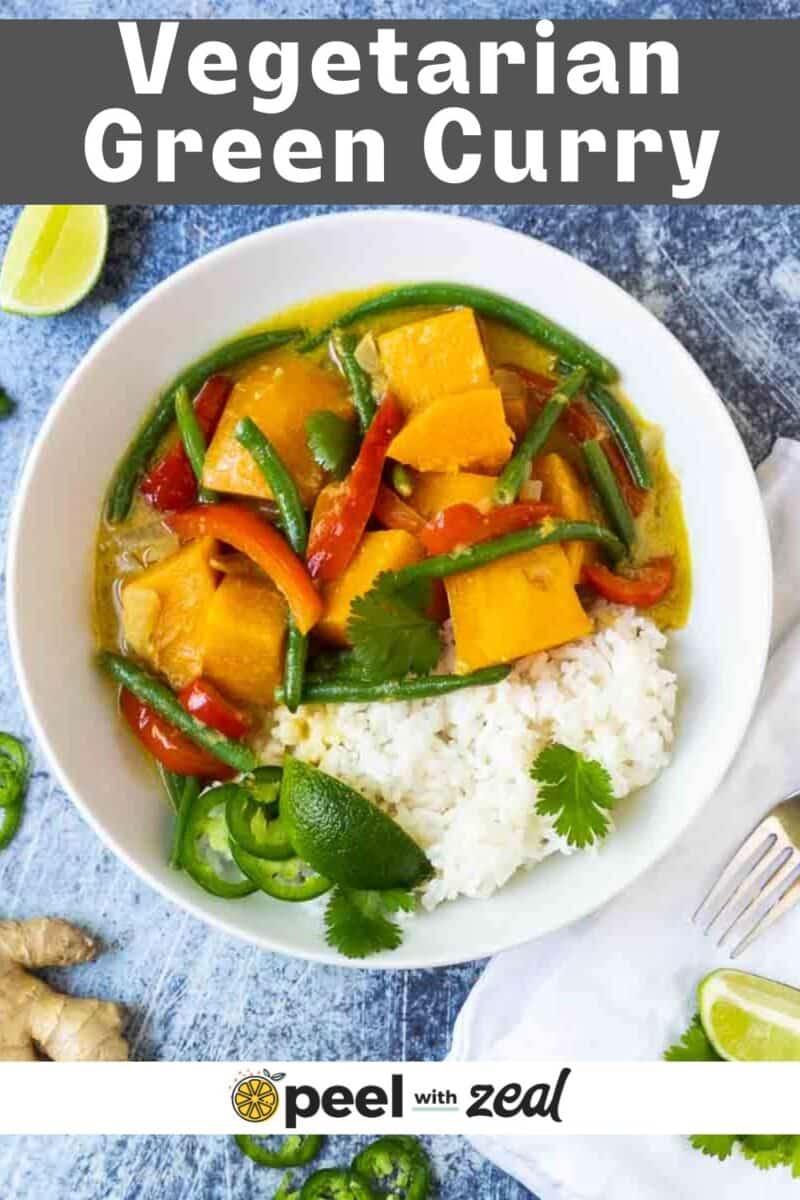 Green curry with vegetables over rice in a bowl.