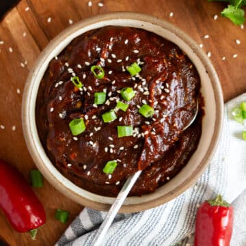 Korean BBQ sauce in a bowl with hot peppers.