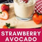 Strawberry avocado smoothie in a glass with coconut and strawberries.