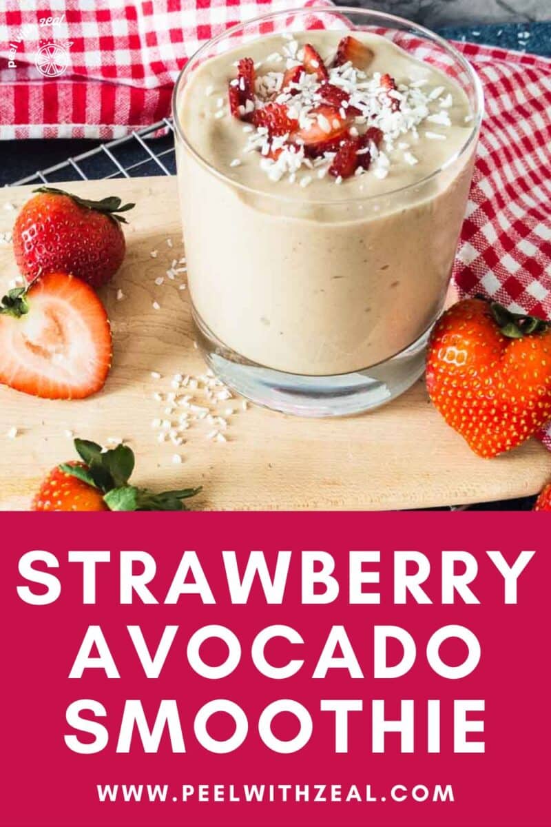 Strawberry avocado smoothie in a glass with coconut and strawberries.