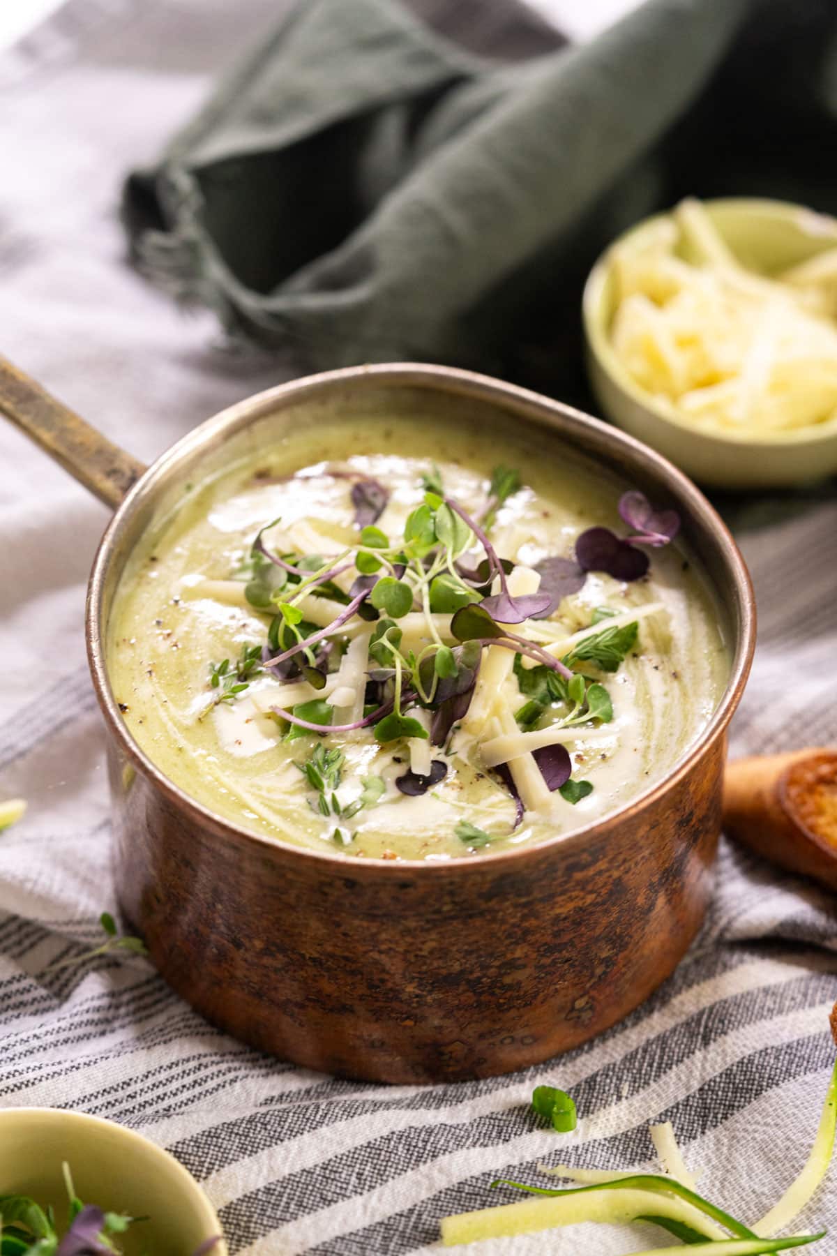 Pot of soup with herbs and grated zucchini.