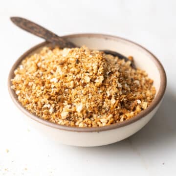 Gluten-free bread crumbs in a bowl with a wooden spoon.