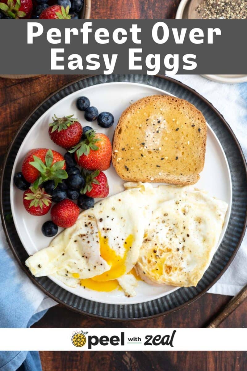 A breakfast plate with over easy eggs, toast and fresh berries.