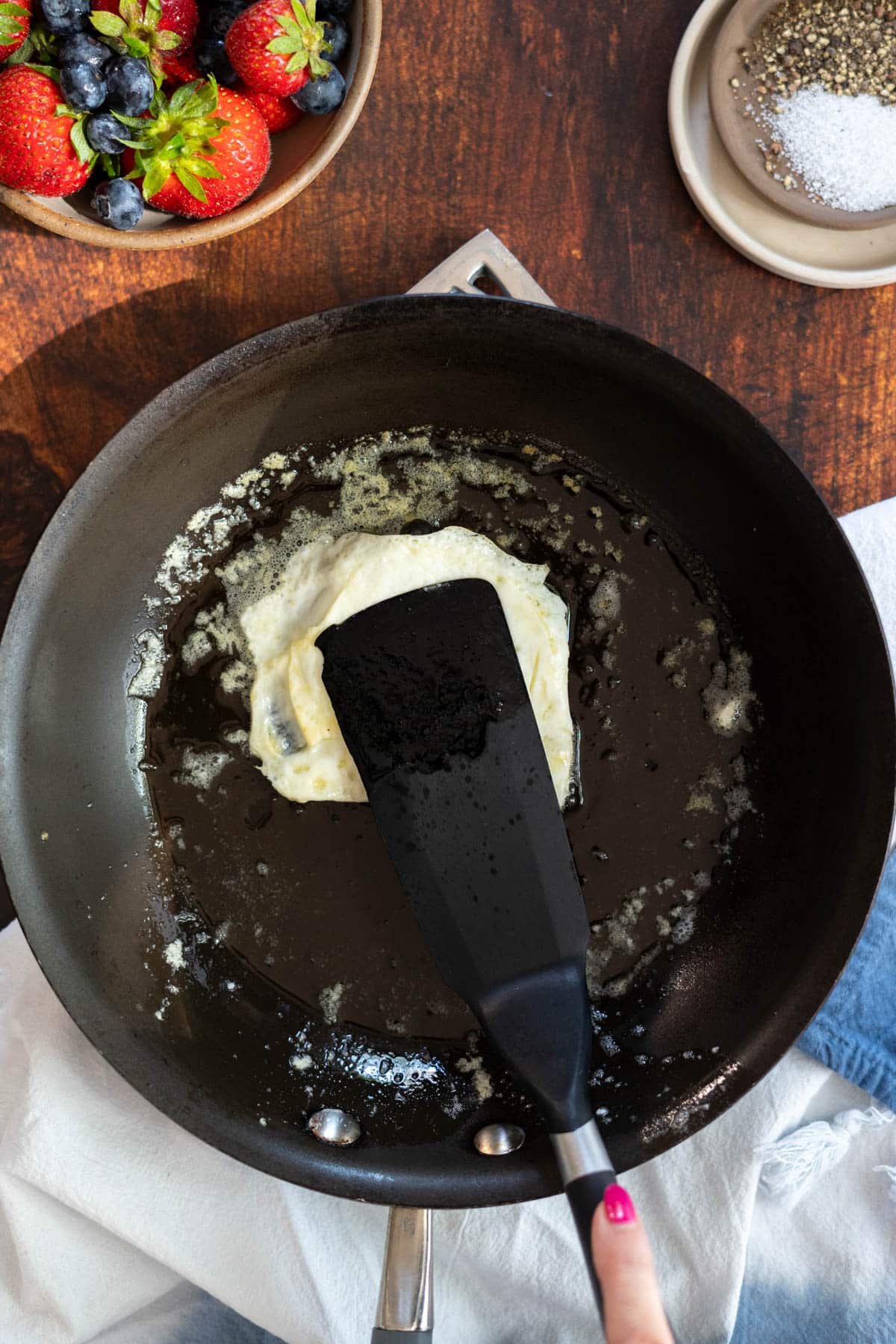 Breaking an egg yolk of a fried egg with a spatula. 