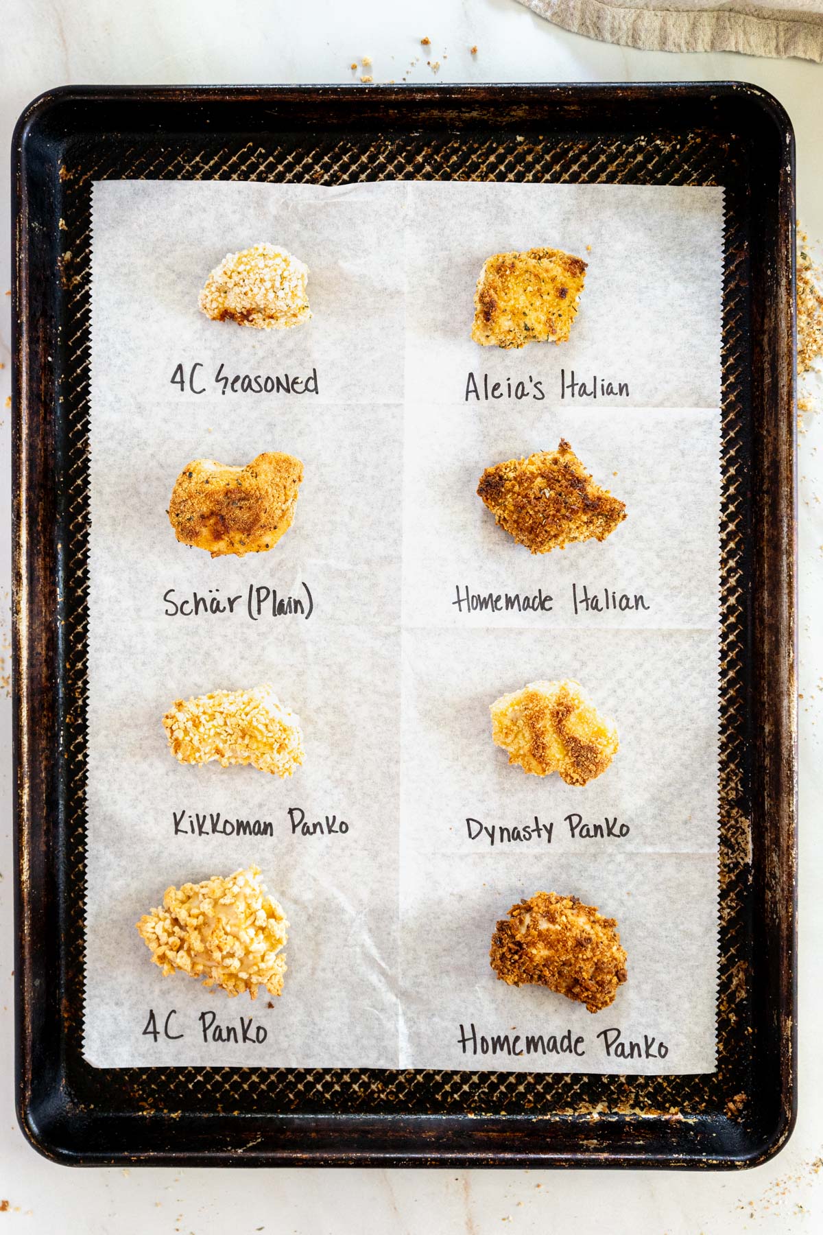 Chicken nuggets with different bread crumb coatings on a sheet pan.
