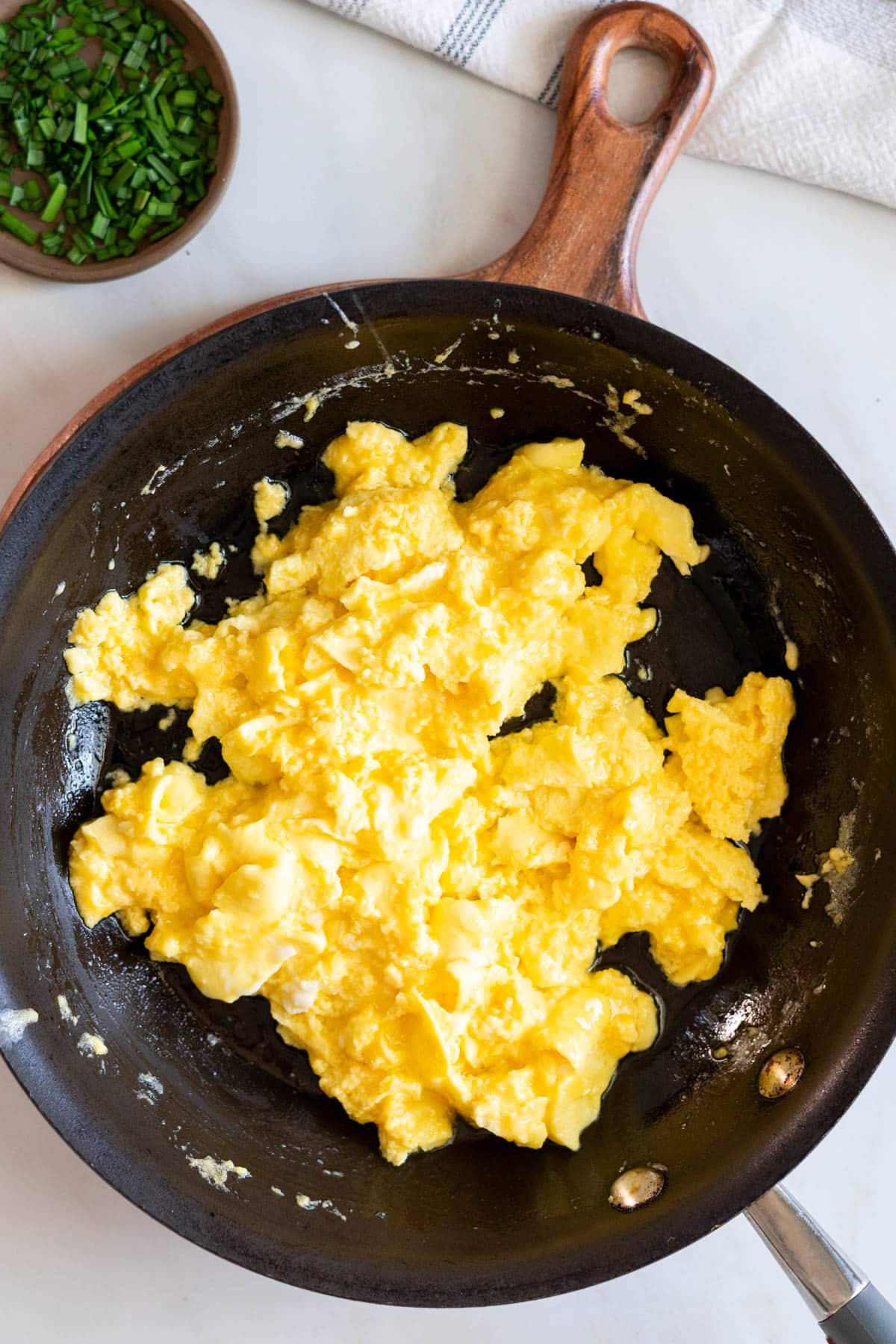 Scrambled eggs with cheese in a pan.