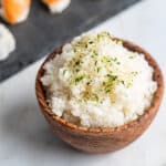 Sushi rice in a wood bowl with furikake seasoning.